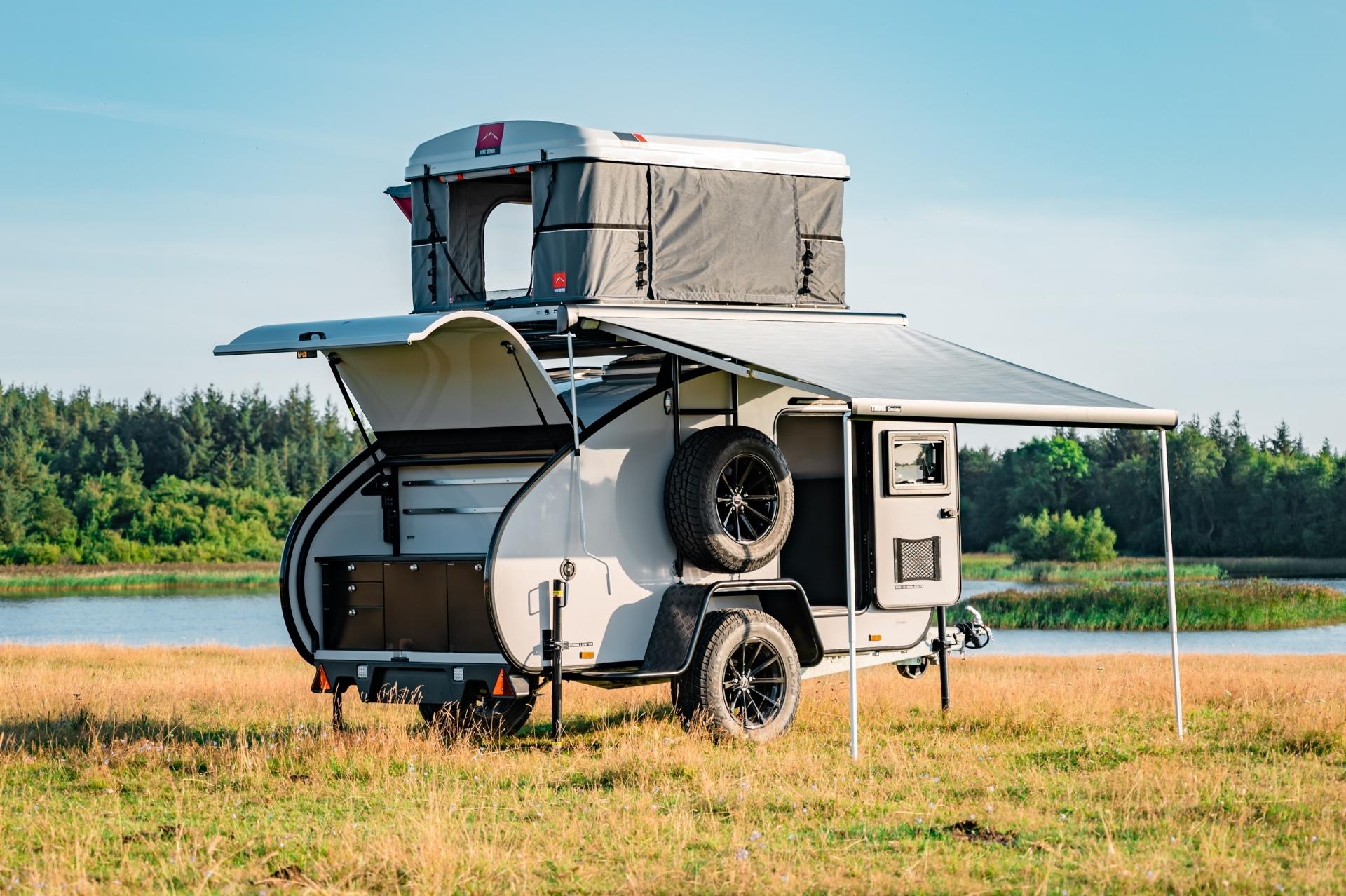HeroCamper Mini-Wohnwagen mit Markise und Auto-Dachzelt. Küchenzeile als Outdoor Campingküche.