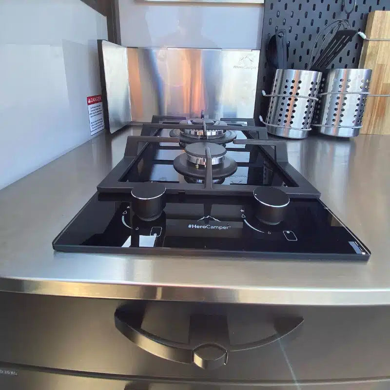 Erweitere deine Hero Camper Küche mit einer integrierten Gasherdplatte mit 2 Kochfeldern (1 x 1,8 kW, 1 x 3,4 kW), gusseisernem Support und automatischer Zündung.